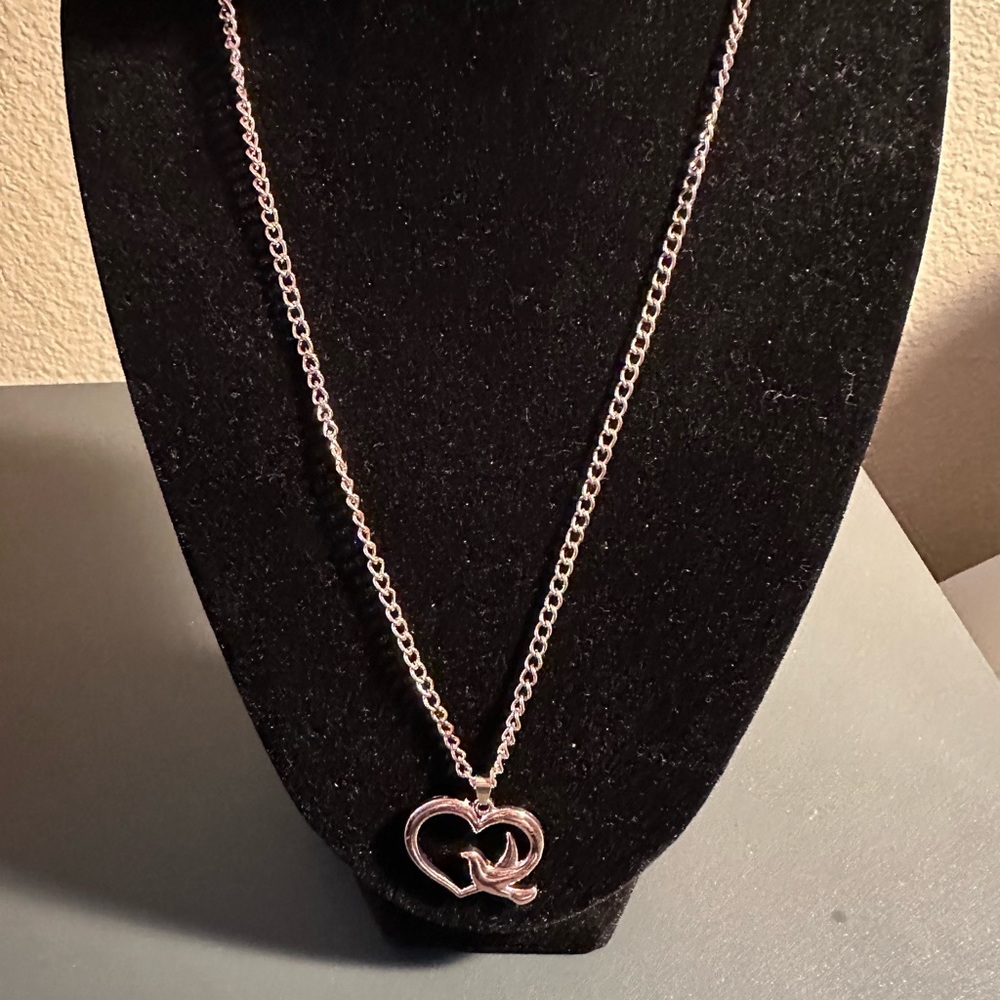 Gold tone heart with dove pendant on a gold tone chain necklace